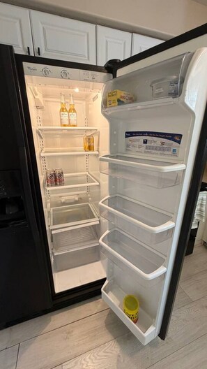 An open refrigerator with multiple shelves and a freezer compartment. - Cozy 3BR Home | King Bed + Smart TVs + Laundry (Charlotte)