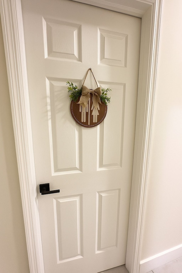 Una puerta blanca con un adorno decorativo y un picaporte negro.