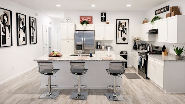 A modern kitchen with white cabinets, a stainless steel refrigerator, and a granite countertop.