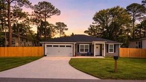 A single-story house with a garage, a front porch, and a driveway leading to the garage.