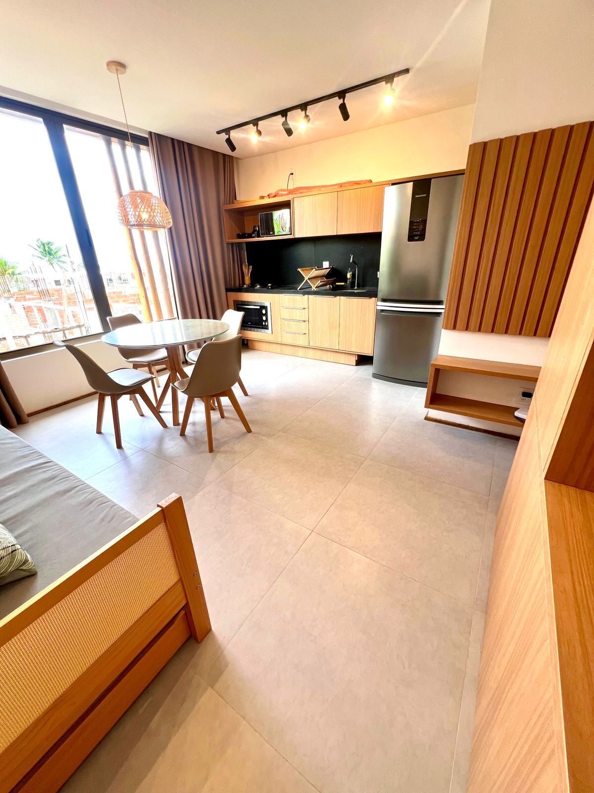 Een moderne keuken met een eethoek, grote ramen en uitzicht op buiten.