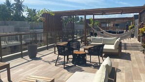 A rooftop terrace with outdoor seating, including sofas and chairs, and a hammock. - Seaside Studio II at “ecologic route of Milagres (Porto de Pedras)