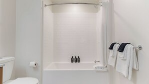 A modern bathroom with a shower, toilet, and towel rack. - Ancora by Avantstay Multi-room Booking in Walkable Little Italy Resort Pool + Sky Deck + Fitness Room (San Diego)
