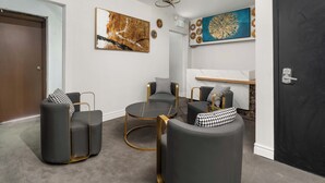 A modern lobby with a reception desk, seating area, and artwork on the walls. - Plush Hotel (toronto)