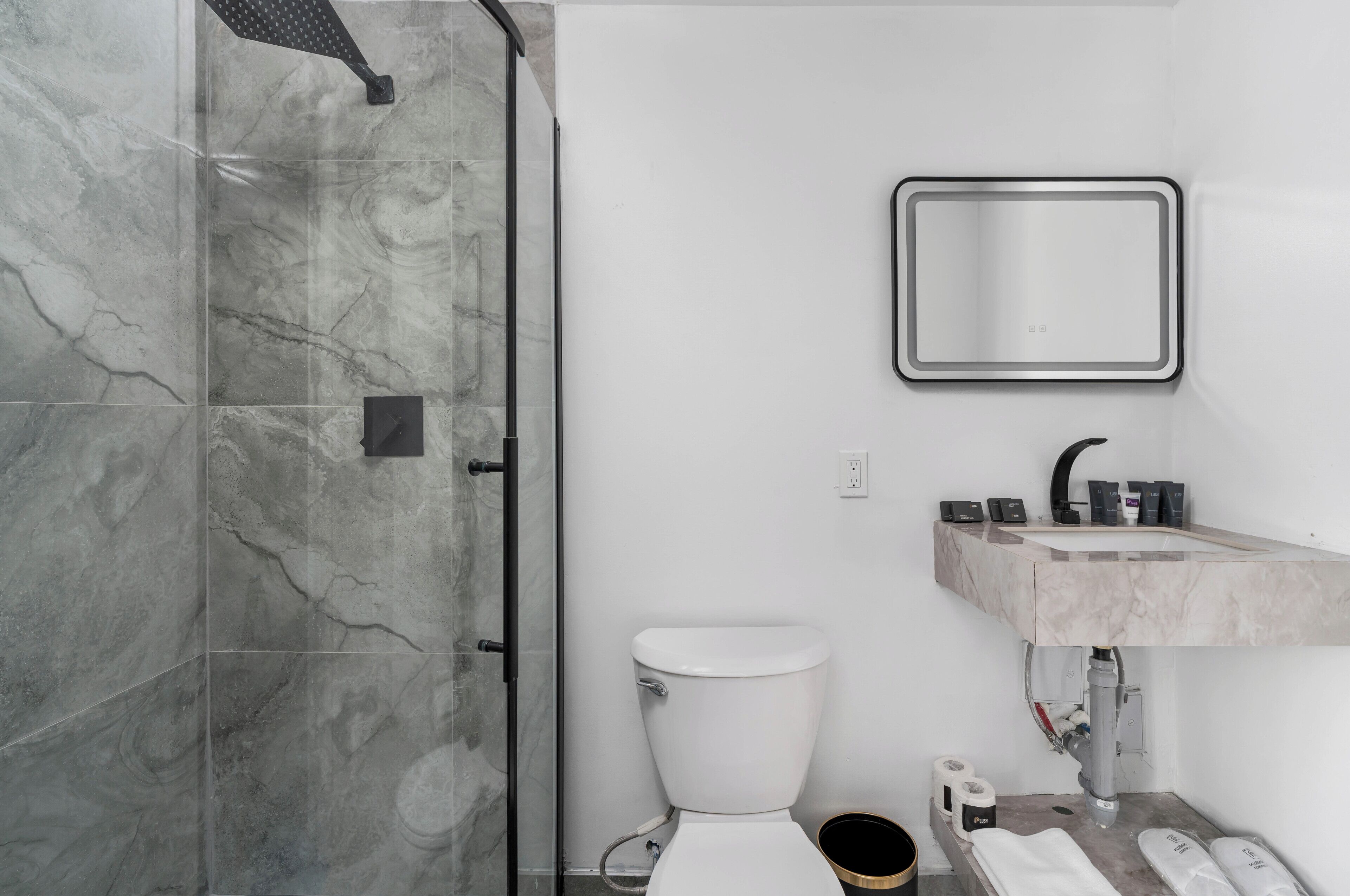 Un bagno con doccia, toilette, lavandino e uno specchio.