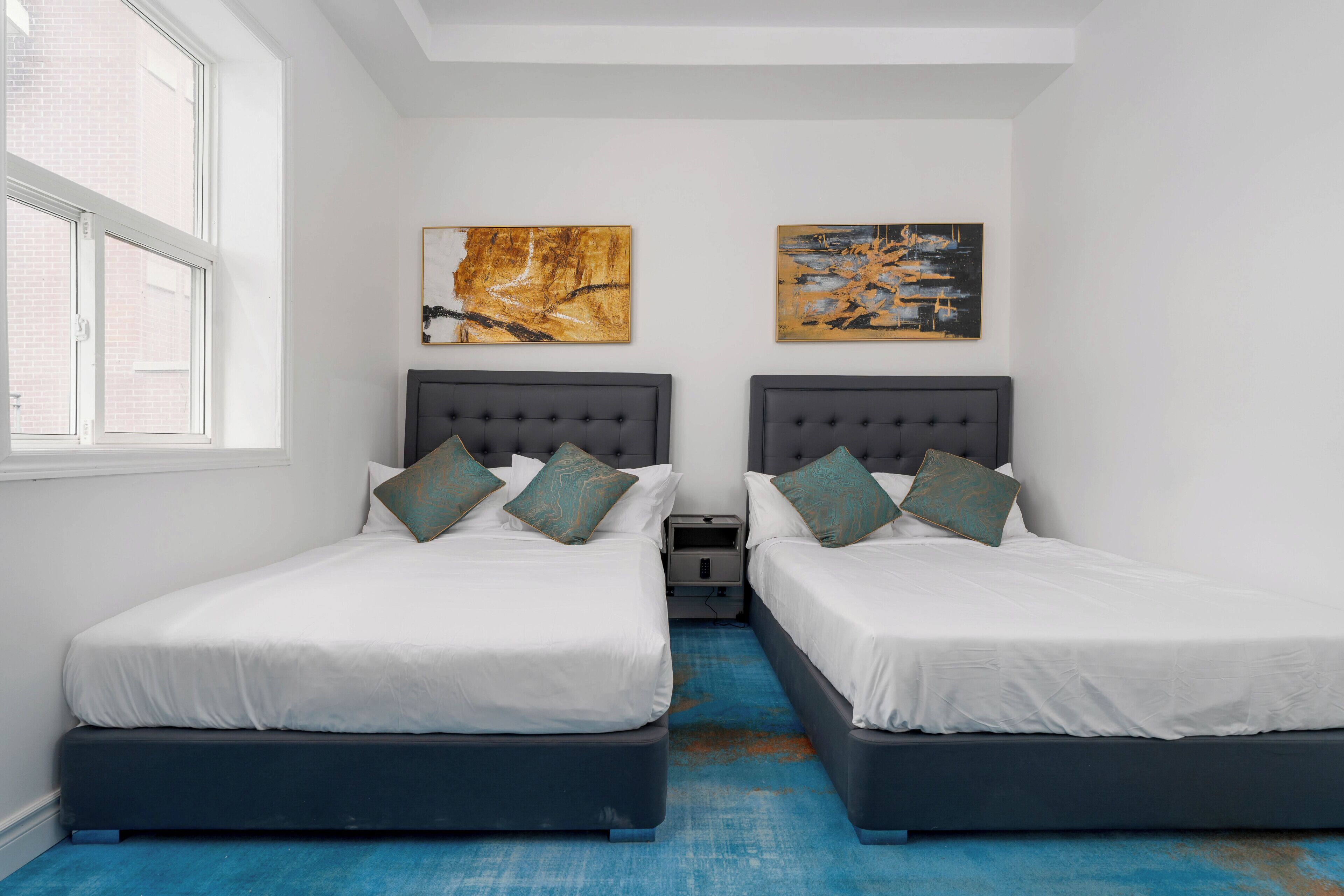 Ein Schlafzimmer mit zwei Betten, einem Nachttisch und einem Bild an der Wand.