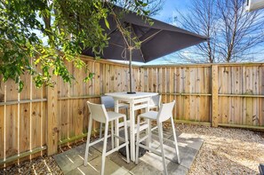 A wooden deck with a table and chairs, surrounded by a wooden fence. - BQ1B - Cozy Corolla Retreat Near Beach & Community Pool (Corolla)