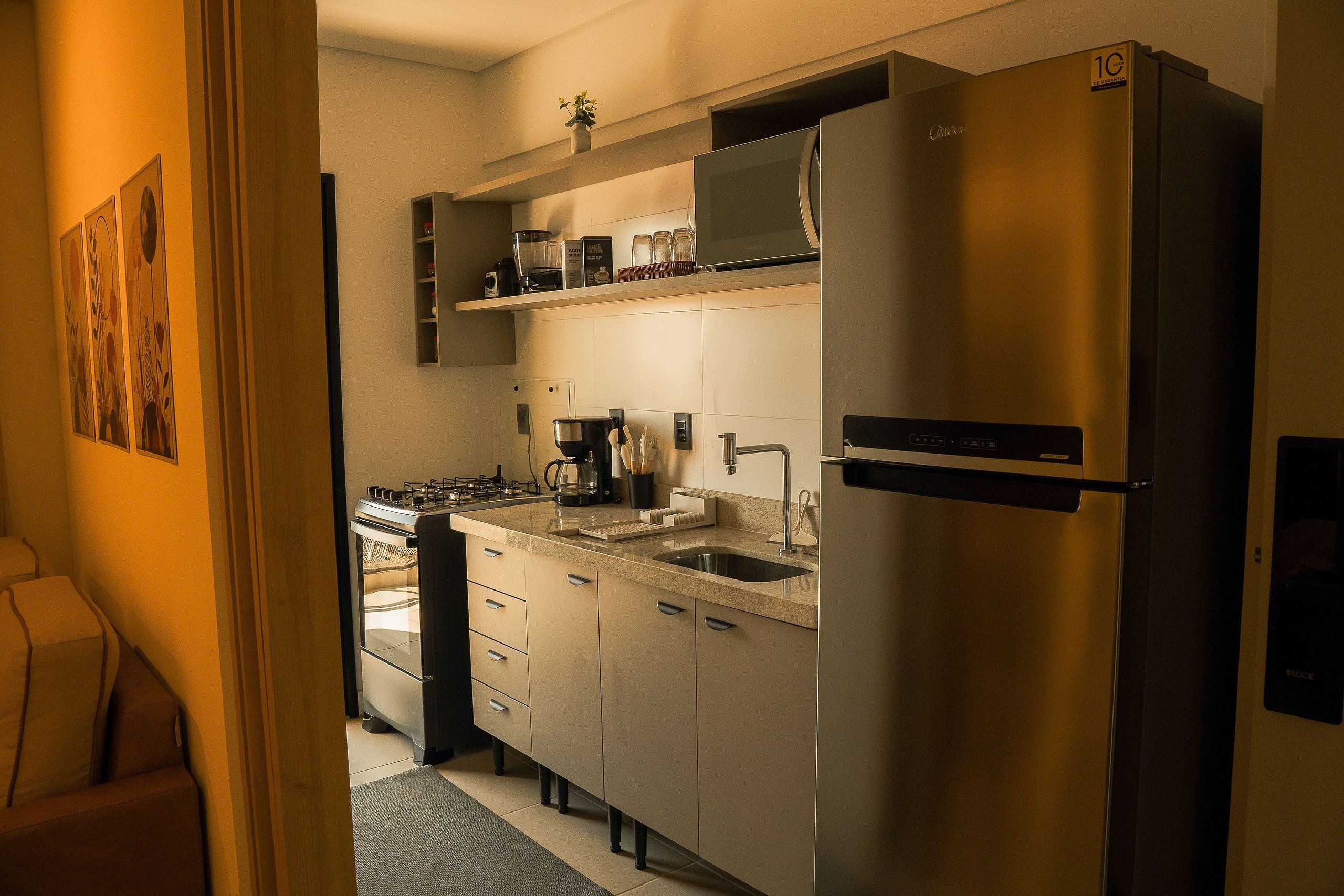 Een moderne keuken met roestvrijstalen apparatuur, een inbouwoven en een koffiezetapparaat.
