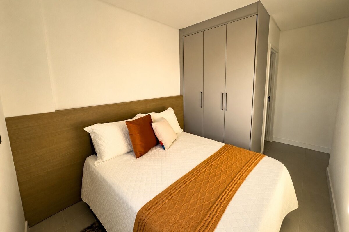 A hotel room with a bed, a wardrobe, and a ceiling light.