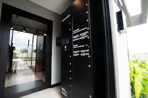 Un ascensor negro con peldaños numerados e instrucciones en portugués, que conduce a una puerta de cristal.