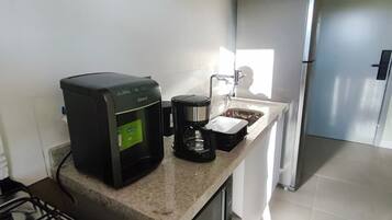 A modern kitchen with a gas stove, coffee maker, and stainless steel appliances.