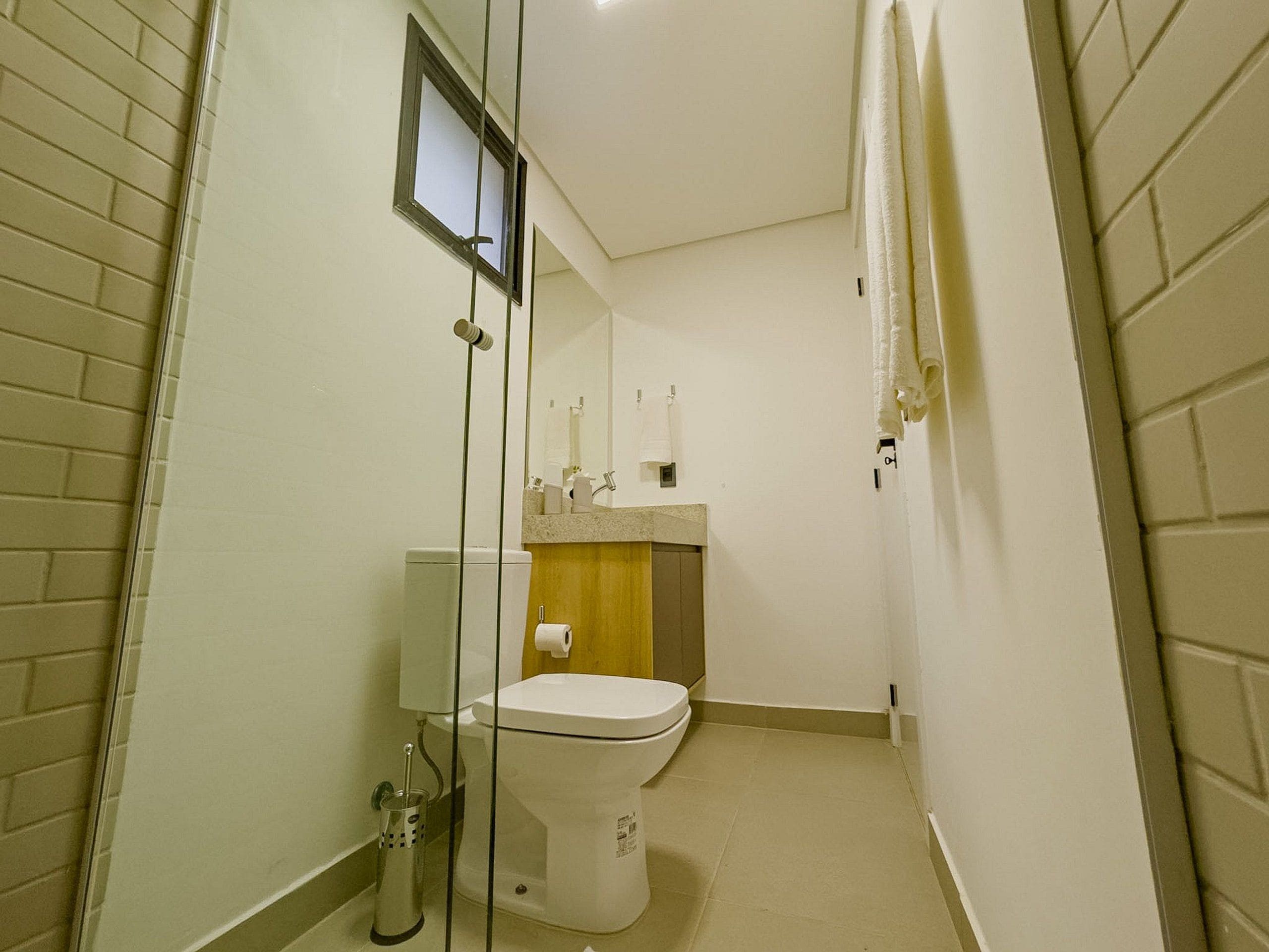 Een kleine badkamer met toilet, wastafel en spiegel.