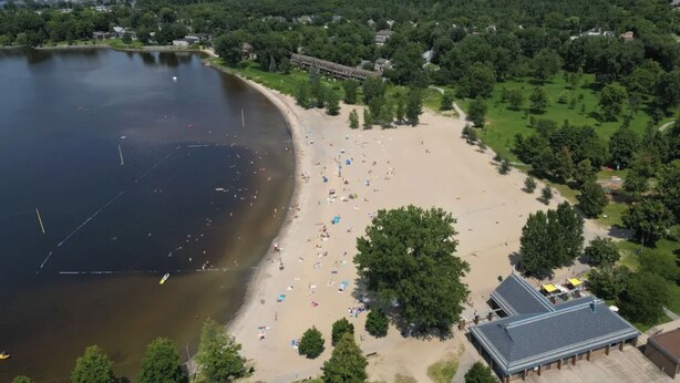 Eine Luftaufnahme eines Strandes mit einem großen Gebäude direkt daneben.