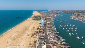 An aerial view of a coastal area with a beach, marina, and residential buildings. - Oceanfront Stay Near Newport Boardwalk (Newport Beach)