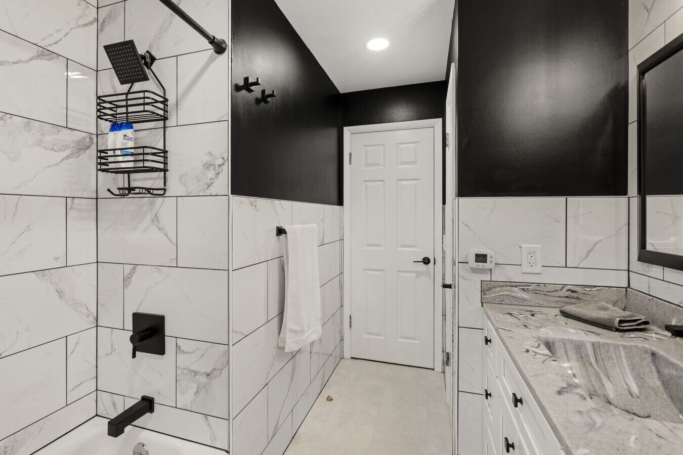 A bathroom with a shower, a towel rack, a toilet, and a sink.