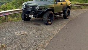 Un SUV Toyota parcheggiato su una strada sterrata con montagne sullo sfondo.