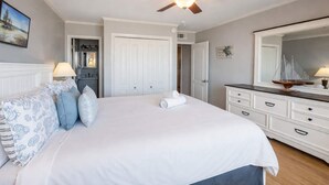 A bedroom with a bed, a dresser, a ceiling fan, and a mirror. - Tilghman Beach & Racquet Club 224 (North Myrtle Beach)