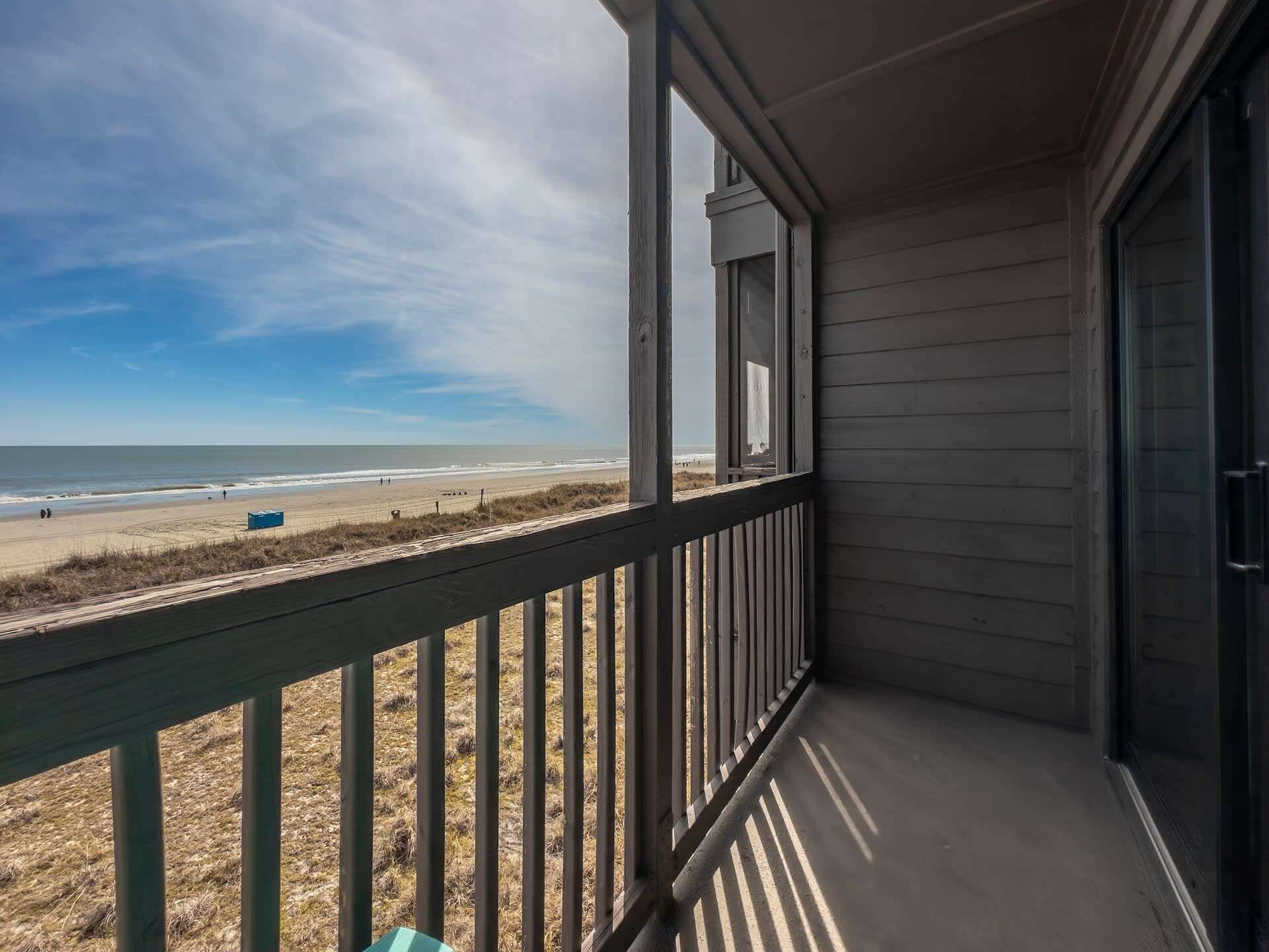 Un balcon avec vue sur la plage et l’océan.
