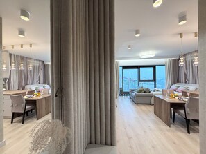 A modern hotel room with a large window, a dining area, and a seating area. - Subtelna Elegancja Olszynki Park (Rzeszów)