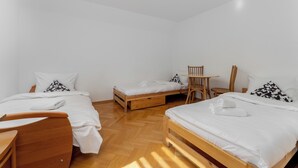 Ein Schlafzimmer mit zwei Betten, einem Holztisch, einem Stuhl und einem kleinen Tisch.