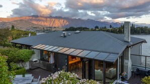 A modern house with a large deck, a barbecue area, and a view of mountains. - The Art House | Queenstown lakefront & central location (Queenstown)