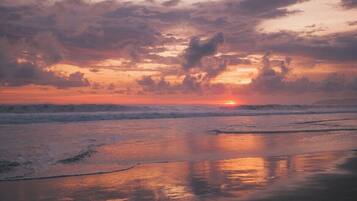 A beach scene with waves and a sunset.