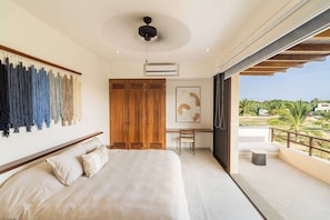 Ein Schlafzimmer mit Bett, Schreibtisch und Blick ins Freie.