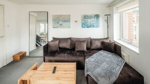 Ein modernes Wohnzimmer mit einer Couch, einem Couchtisch und Kunstwerken an den Wänden.