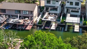 A waterfront property with multiple buildings, docks, and boats. - Luxury 3-Story Lakehouse |Pool + Hot Tub + Sundeck (Horseshoe Bay)