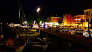 Een jachthaven met aangemeerde boten, een gebouw in kasteelstijl en het hotel 'HOTEL CATAVILLE' op de achtergrond.