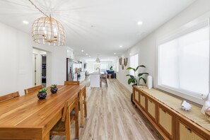 Eine geräumige Küche mit Holzausstattung, einer zentralen Kochinsel und einem Essbereich mit Holztisch und Stühlen.