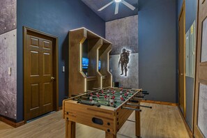 A room with a foosball table, a door, and a wall with a character mural. - Grande Golfview at Reunion-TT490 (Kissimmee)