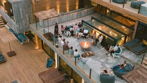 A multi-level outdoor lounge area with seating, a fire pit, and a pool. - Noah Surf House (Torres Vedras)