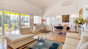 Ein geräumiges Wohnzimmer mit Sofa, Couchtisch und Essbereich.