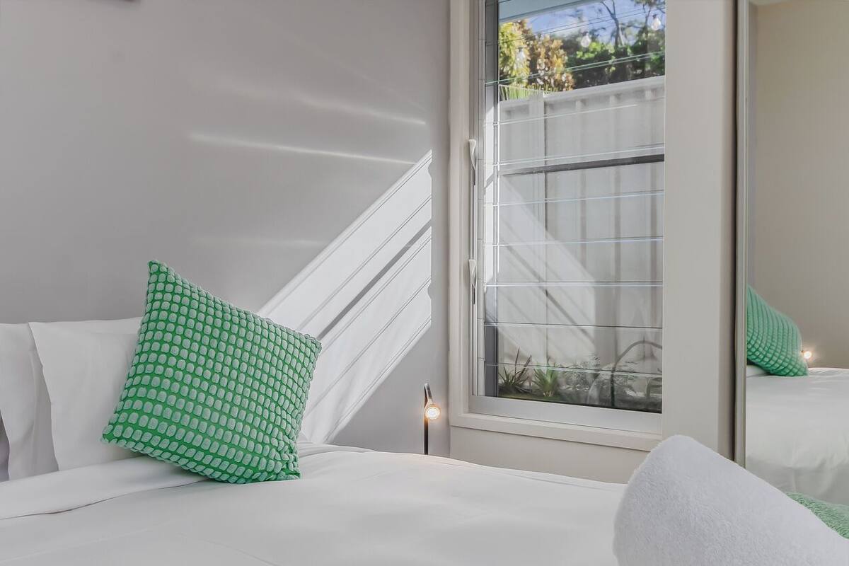 A hotel room with a bed, a window, and a view of the outside.