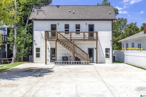 Une maison à deux étages avec un porche à l’avant, un escalier et un garage.
