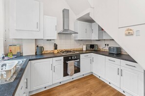 A modern kitchen with white cabinets, a gas stove, a microwave, and a toaster. - 2 Bedroom Birmingham J Quarter with Parking & WiFi (Birmingham)