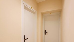 Two white doors with brass handles, numbered 02 and 03, in a hallway with beige walls. - Grandstay Tirana Central 01 (Tirana)