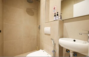 Ein Badezimmer mit Dusche, Waschbecken und Pflegeprodukten.