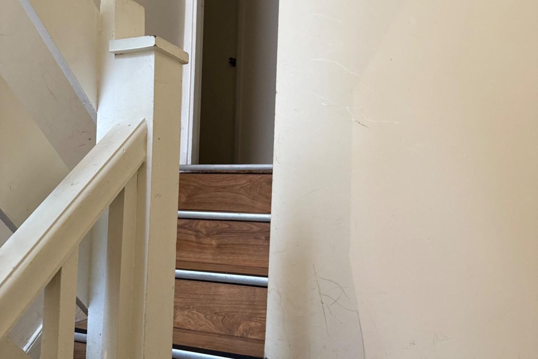Eine Treppe mit Holzboden und weißen Geländern.