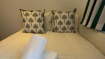 Tabla de planchar con plancha, wifi y ropa de cama