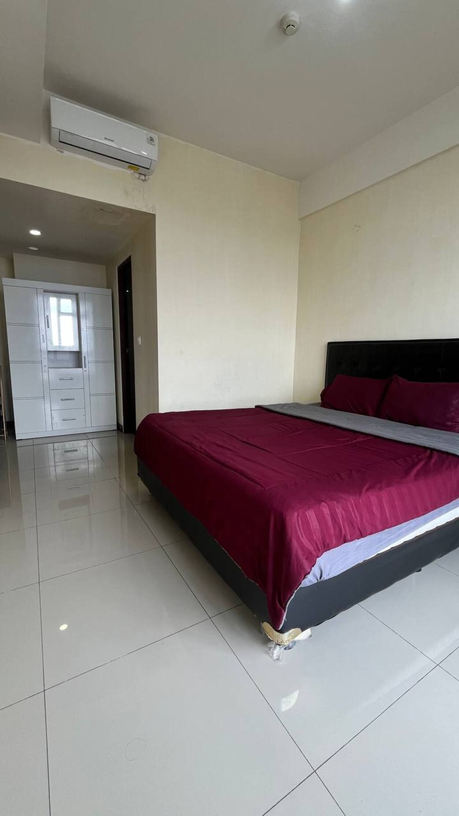 Une chambre à coucher comprenant un lit, une armoire et un appareil de climatisation.