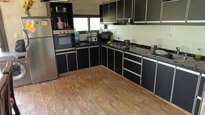 A modern kitchen with a central island, built-in appliances, and a view of the outdoors. - COUNTRY HOUSE FOR 10 PEOPLE MERLO SAN LUIS (Córdoba)