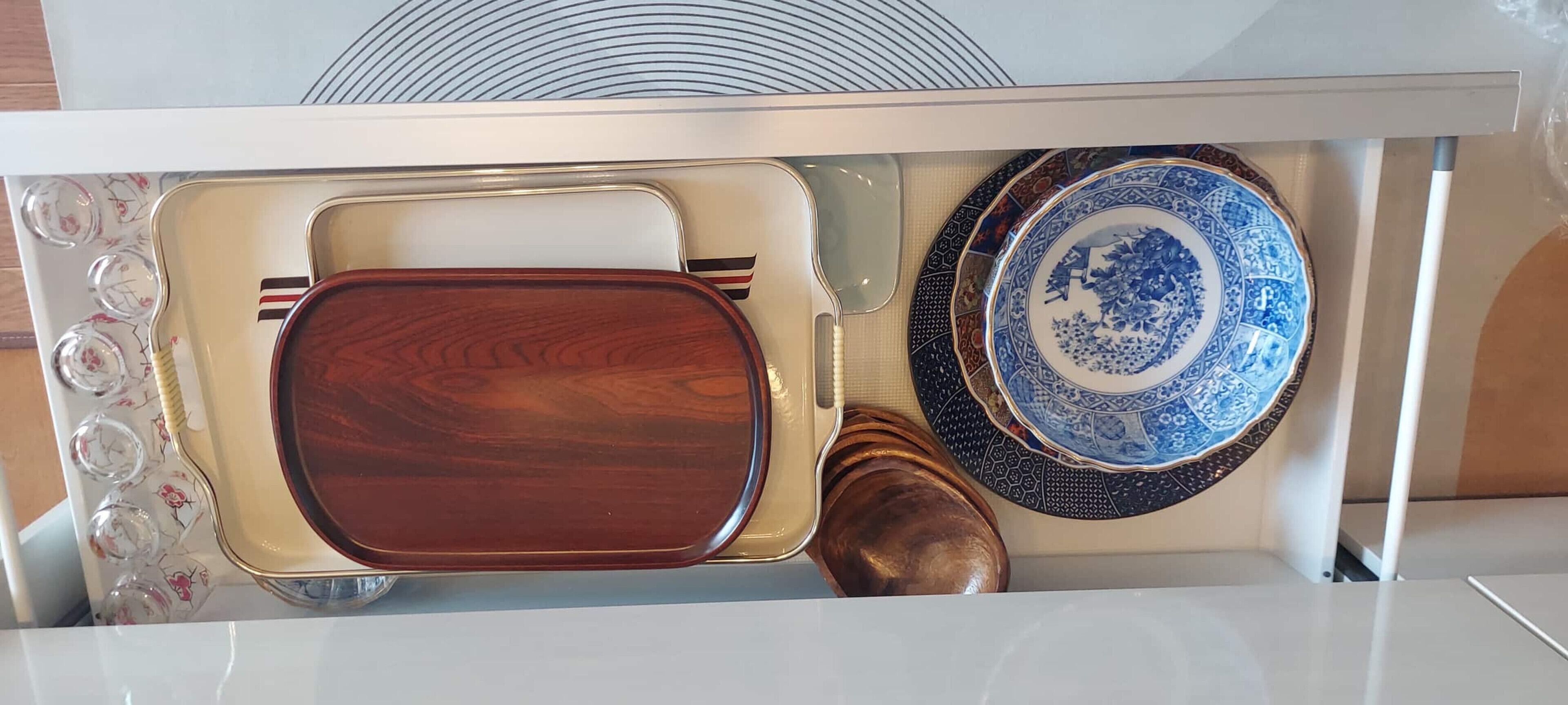 Un four à micro-ondes avec un plateau en bois et une assiette à motifs bleus et blancs.