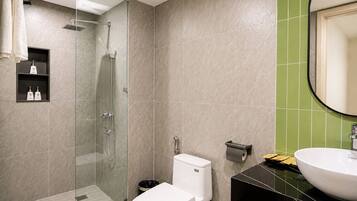 A modern bathroom with a glass-enclosed shower, a white toilet, and a black vanity with a white sink.
