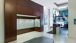 Een moderne hotelkamer met een houten accentmuur, een groot raam en een werkplek.