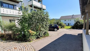 A building with a paved driveway, a parked car, and a clear sky. - Apparthotel Garni Superior Simsseeblick (Bad Endorf)
