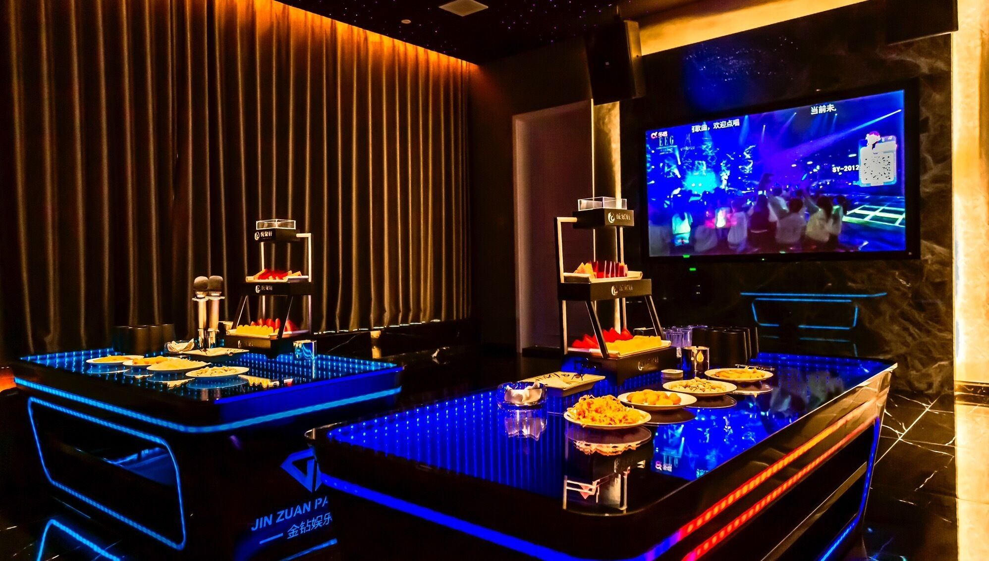 Eine Bar mit Neonbeleuchtung, einem Fernsehbildschirm und einer Speisenauslage.