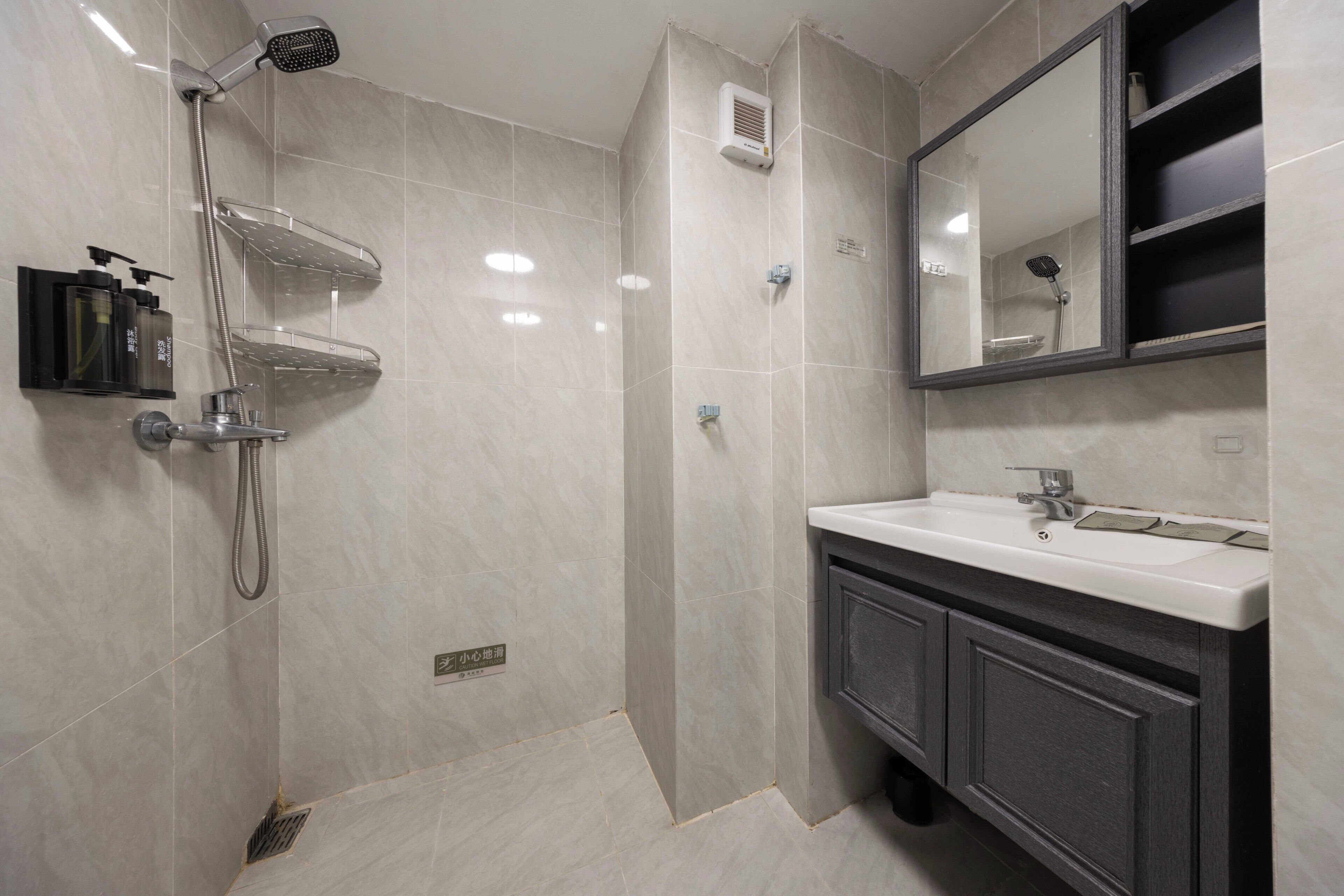 Un baño moderno con ducha, lavamanos y espejo.