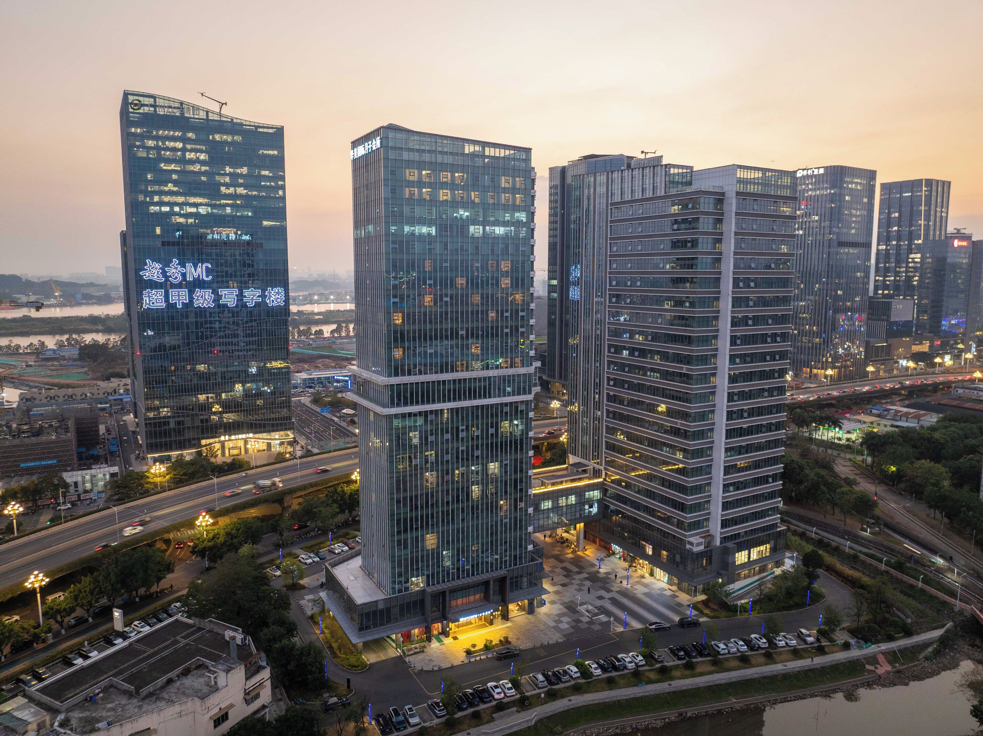 A high-rise building complex with multiple glass facades, a central courtyard, and surrounding roads.